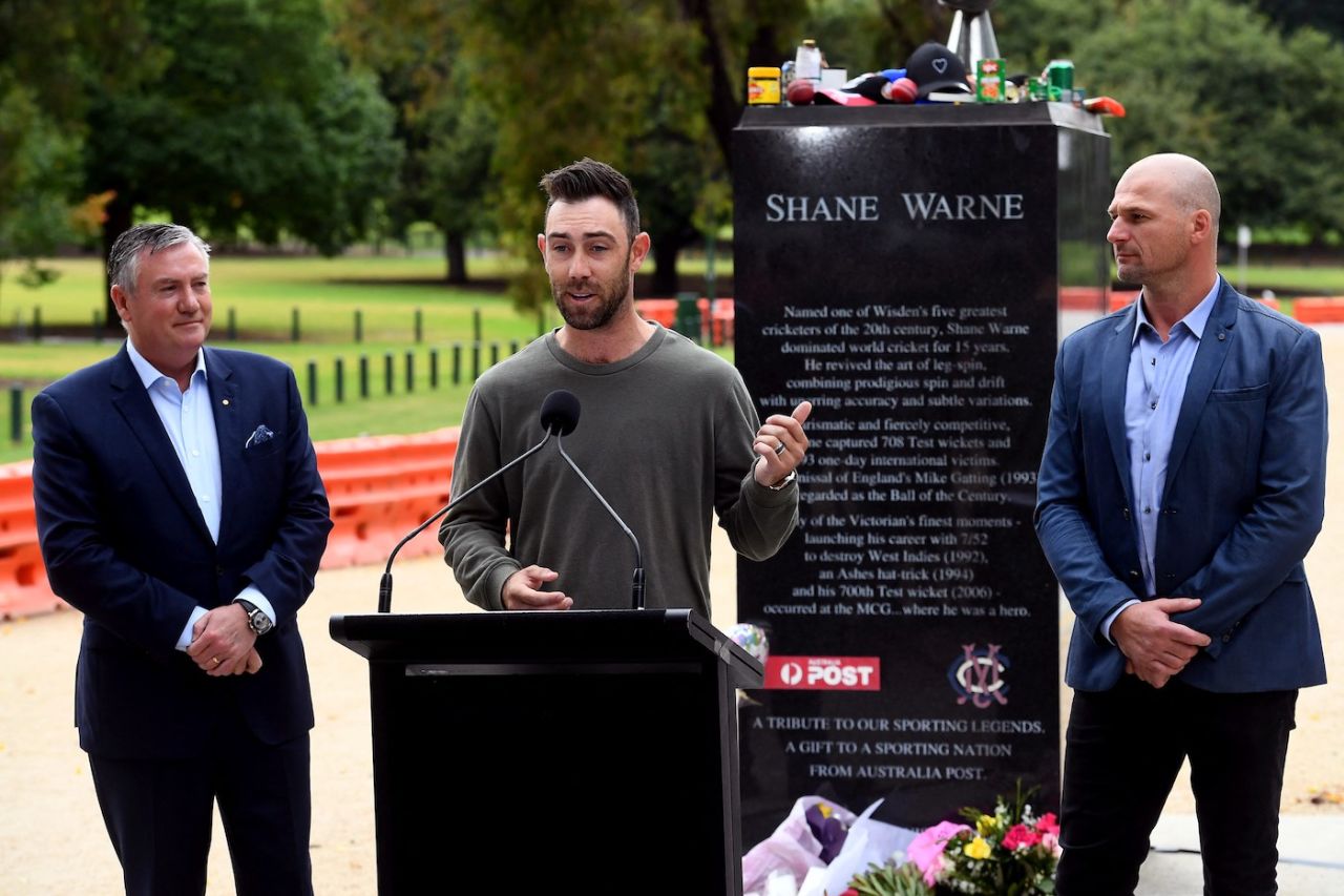 Glenn Maxwell speaks in front of a statue of Shane Warne, in the presence of Eddie McGuire (left) and Aaron Hamill (right), Melbourne, March 29, 2022