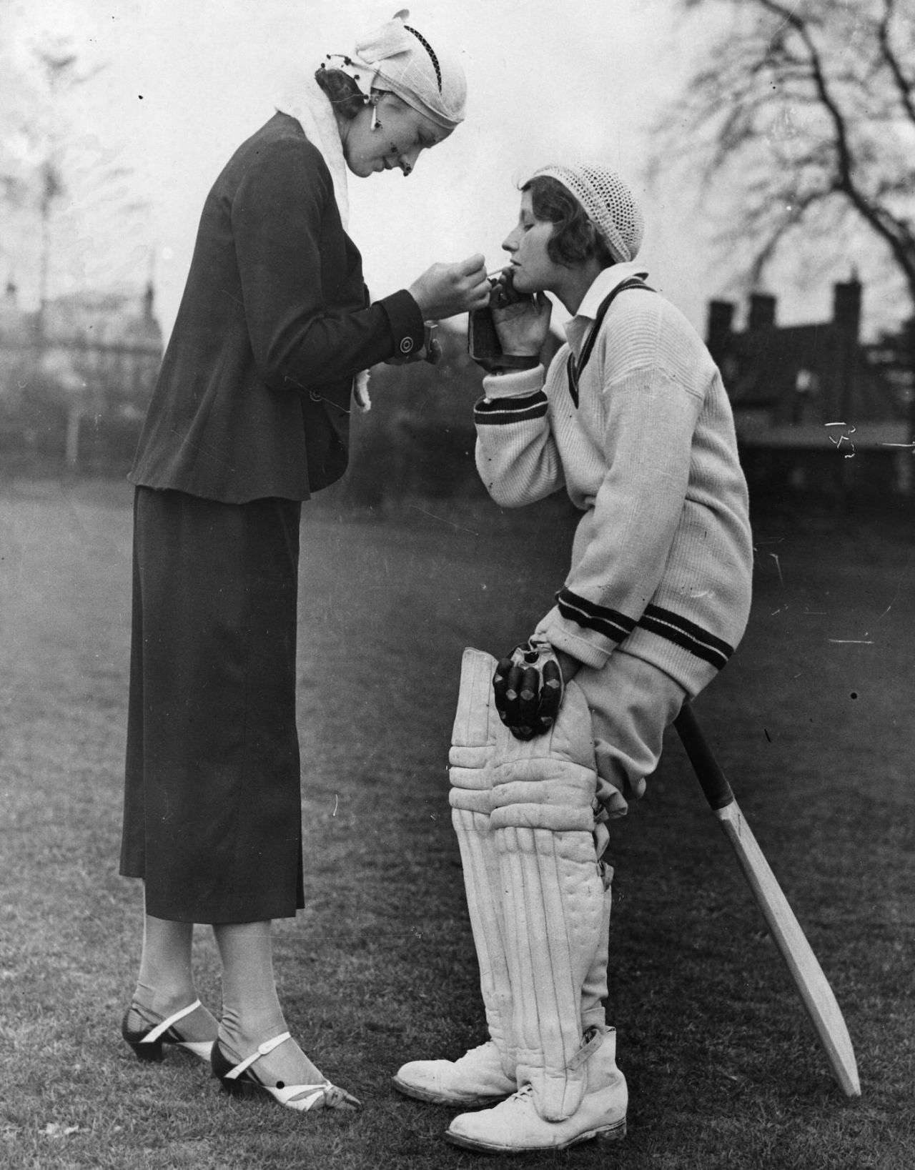 A cricketer has her cigarette lit before facing the bowling during a practice match in Hertfordshire, May 25, 1935