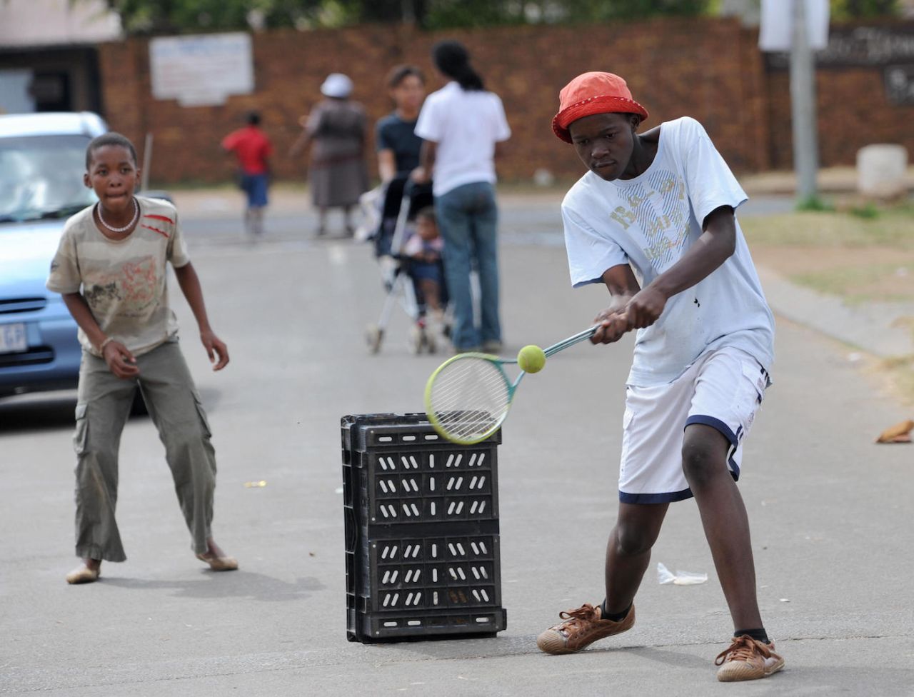 Kids play cricket with squash rackets in the street, Soweto, Johannesburg, April 11, 2009