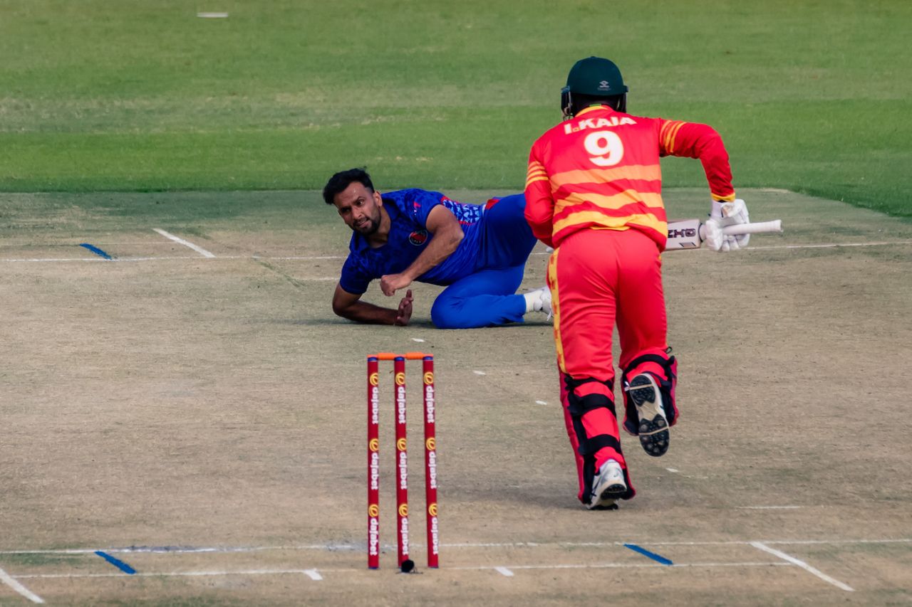 Fareed Ahmad falls in his follow-through as Innocent Kaia takes a run, Zimbabwe vs Afghanistan, 1st ODI, Harare, June 4, 2022
