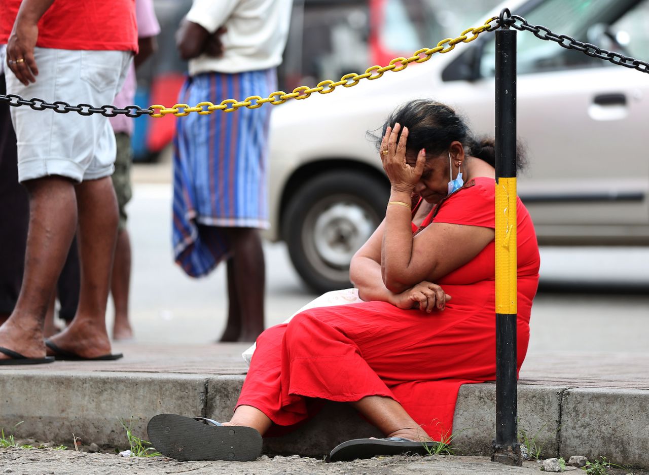 A woman waits to buy kerosene at a fuel station in Colombo, June 7, 2022. 
