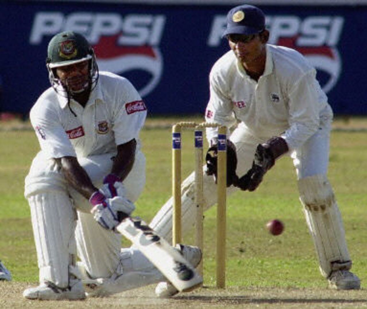 Bangladeshi batsman Aminul Islam sweeps a ball as Sangakkara looks on, Bangladeshi batsman Aminul Islam sweeps a ball as Sangakkara looks on