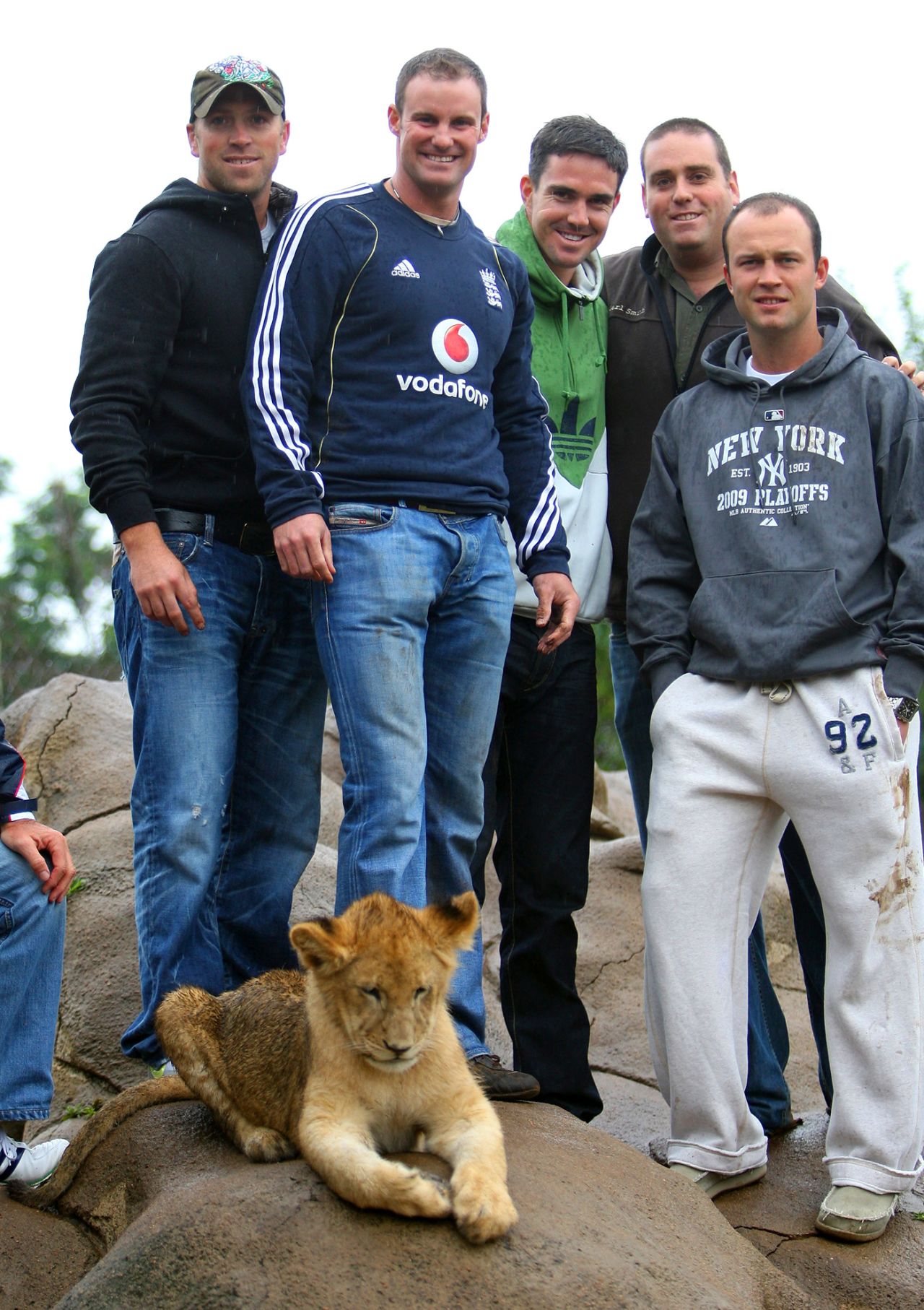 Matt Prior, Andrew Strauss, Kevin Pietersen and Jonathan Trott, along with a tour guide, pose for photos with a lion cub during a visit to Johannesburg Lion Park, November 18, 2009