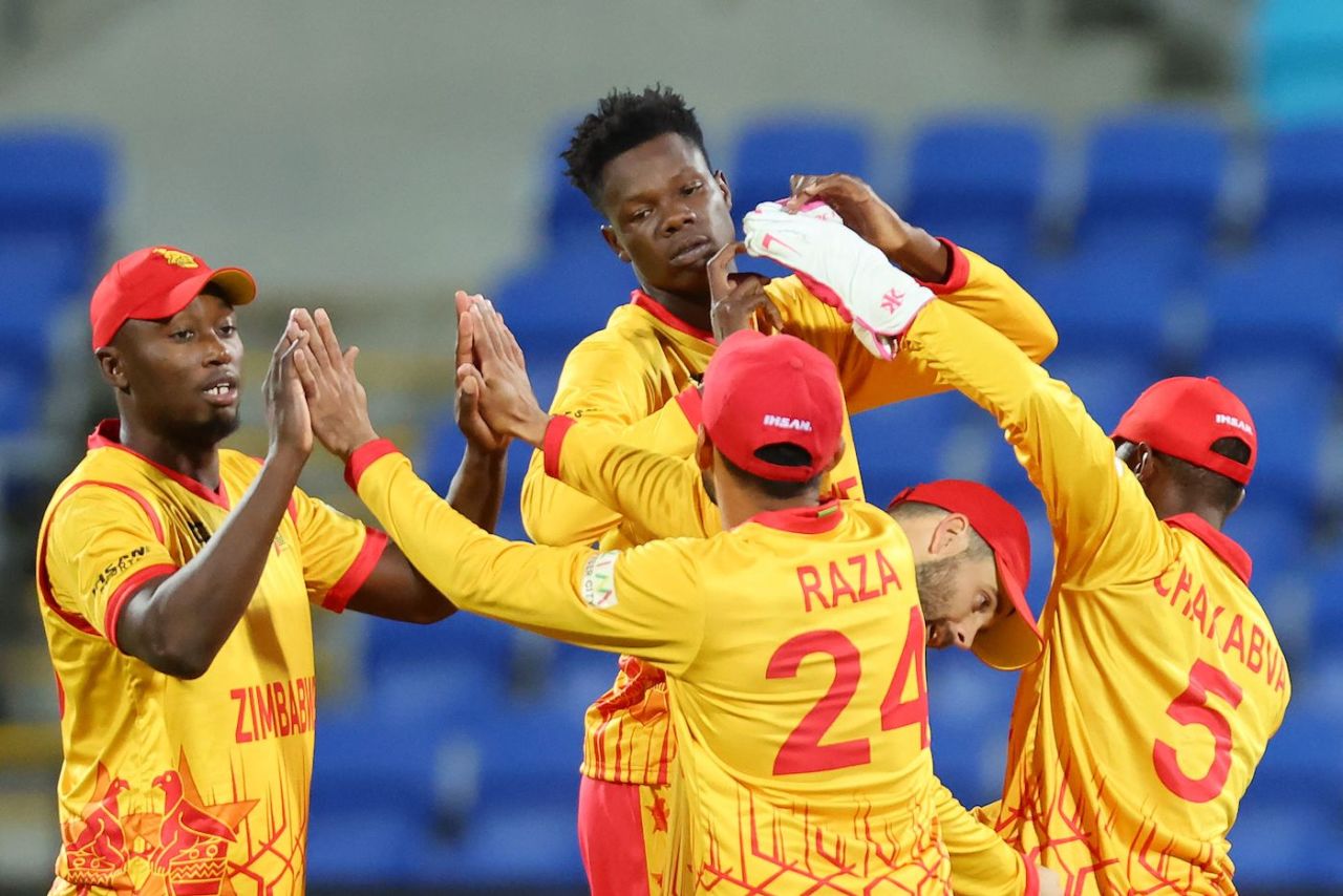 Blessing Muzarabani and Tendai Chatara tag along with team-mates at the end of Ireland's innings, Scotland vs Zimbabwe, ICC Men's T20 World Cup, Hobart, October 21, 2022 