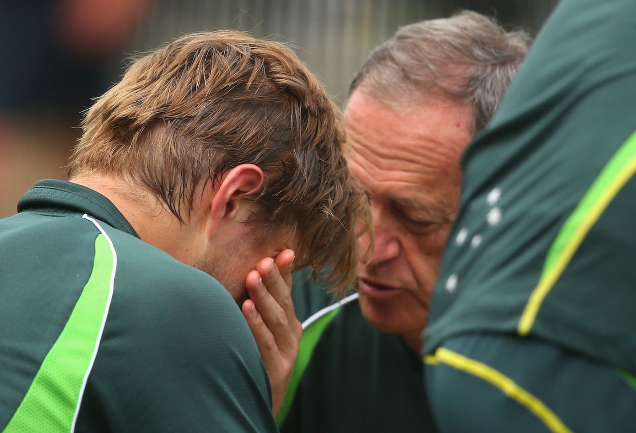 Shane Watson is seen to after being struck in the helmet by a bouncer at training, Melbourne, December 23, 2014