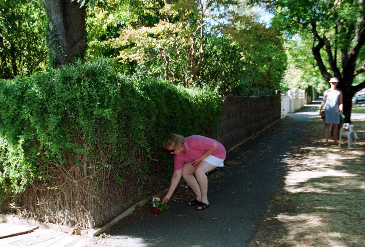 A fan places a flower on the footpath outside Don Bradman's home in Kensington Park, Adelaide, after the announcement of Bradman's death, February 26, 2001
