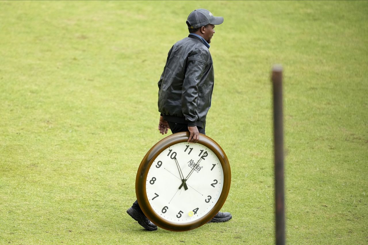 A member of the ground staff carries a clock across the pitch, Zimbabwe vs West Indies, 1st Test, Bulawayo, second day, February 5, 2023