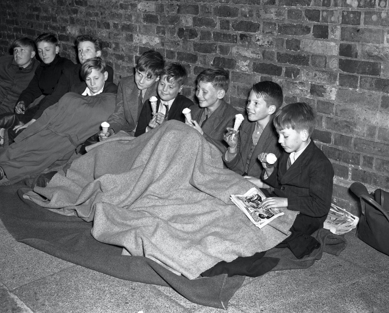Schoolchildren enjoy ice cream before settling down for the night as they queue at The Oval in the hope of seeing the match, fifth Test, England vs Australia, August 14, 1953