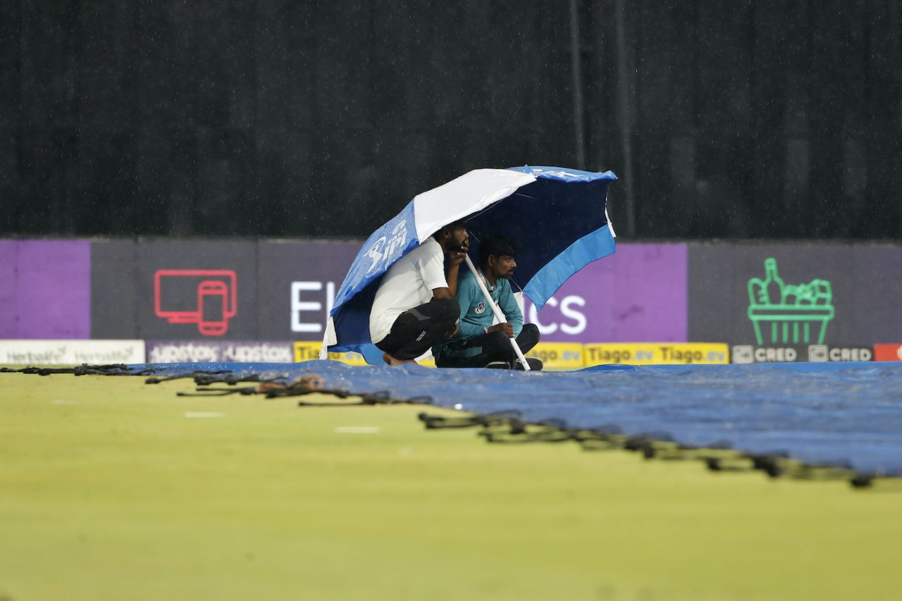 Members of the groundstaff take refuge under the umbrella during rain, Lucknow Super Giants vs Chennai Super Kings, IPL 2023, Lucknow, May 3, 2023