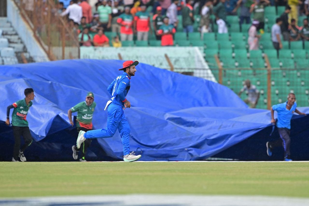 Rahmat Shah runs off as the groundstaff members cover the ground, Bangladesh vs Afghanistan, 1st ODI, Chattogram, July 5, 2023