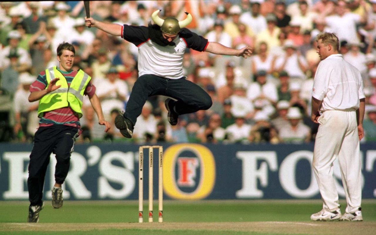 A pitch invader dressed as a Viking hurdles the stumps as Shane Warne looks on, fourth day, third Test, England vs Australia, the Ashes, July 6, 1997
