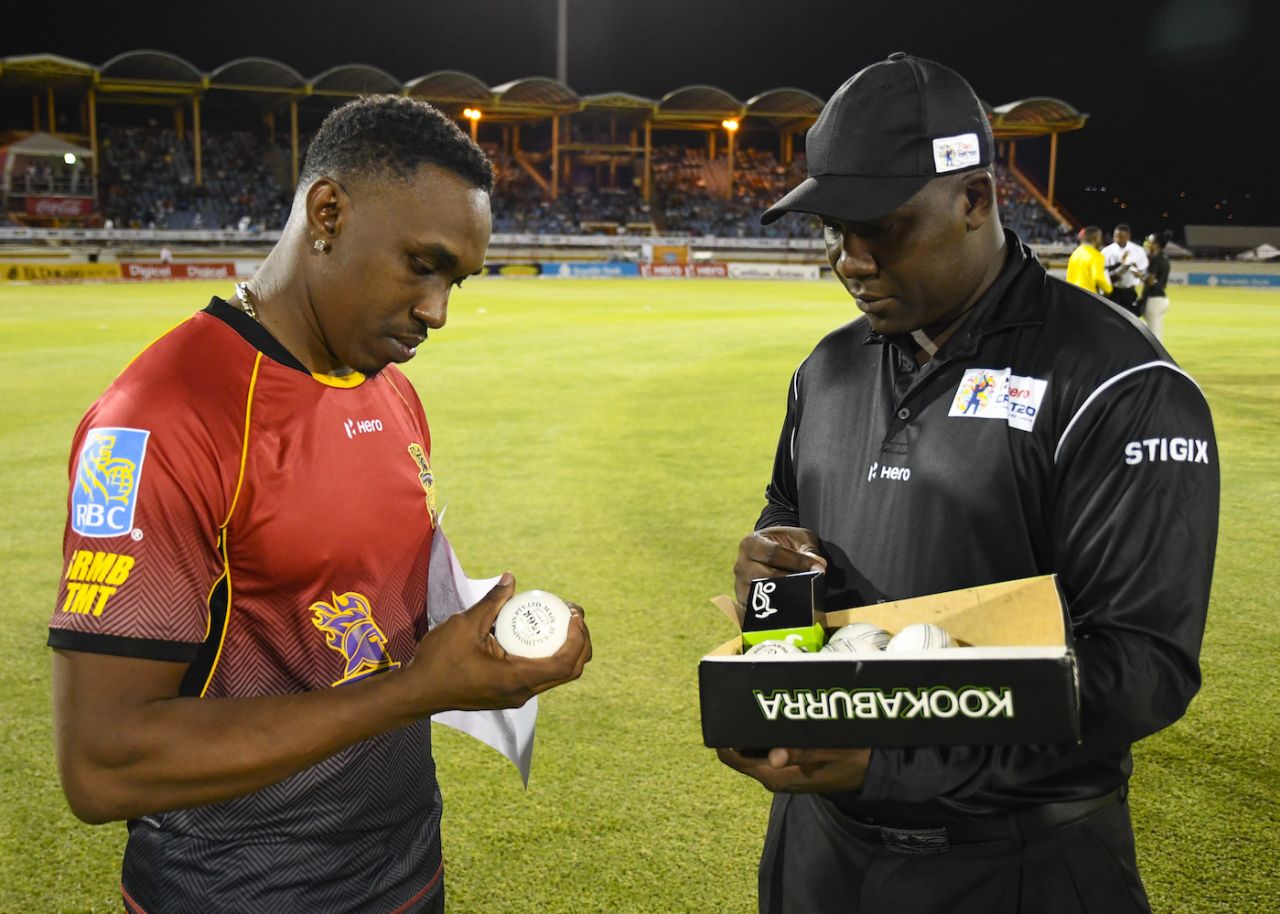 Dwayne Bravo chooses a ball from reserve umpire Myron James, Gros Islet, August 5, 2017