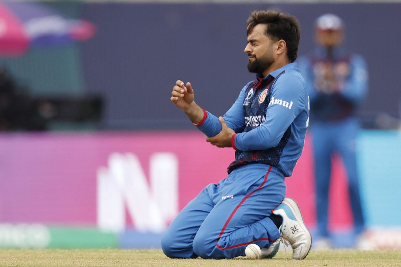 Rashid Khan holds his forearm in pain after fielding a ball off his own bowling, Afghanistan vs Bangladesh, World Cup, Dharamsala, October 7, 2023