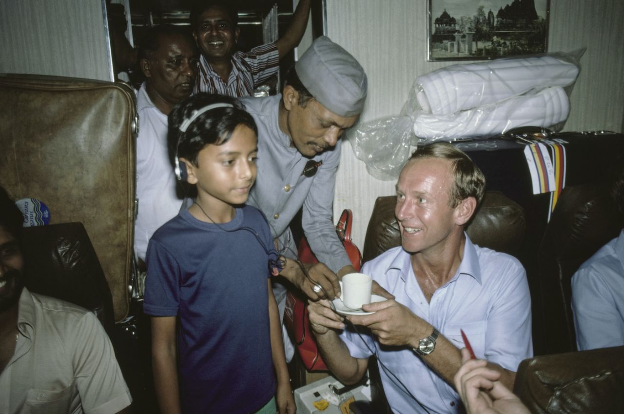 Derek Underwood grabs a cup of tea while a boy listens to his Walkman on the train to Pune, England tour of India, November 10, 1981
