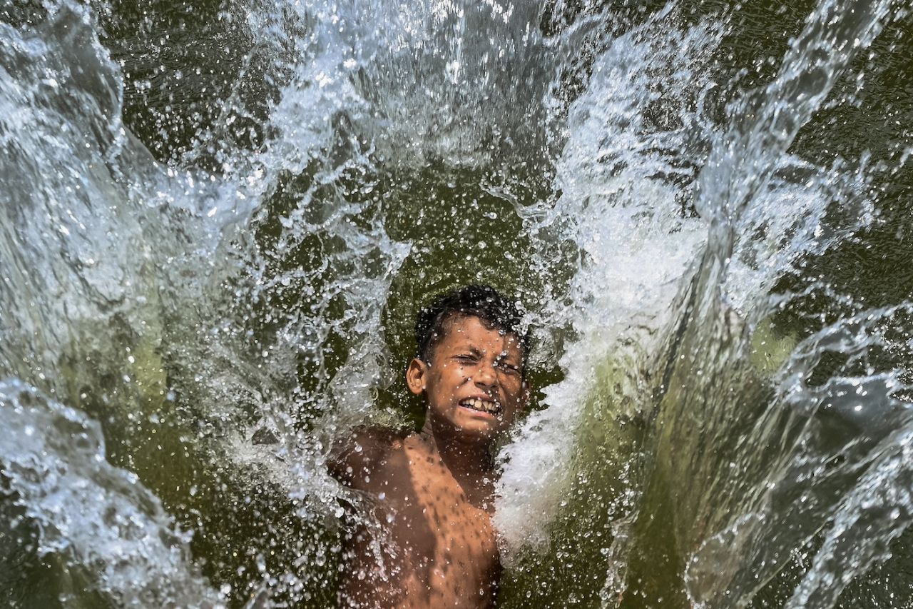 A child takes a dip in a lake to cool off during the heatwave in Dhaka, April 29, 2024