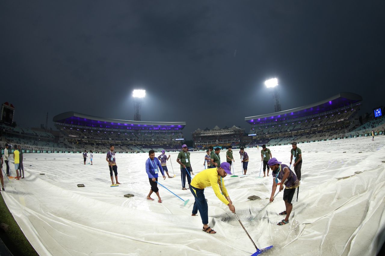 Ground staff mop water off the covers at Eden Gardens ahead of the match, Kolkata Knight Riders vs Mumbai Indians, IPL 2024, Kolkata, May 11, 2024