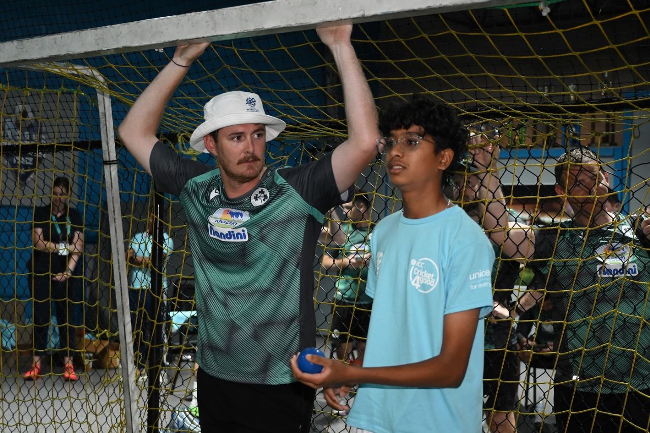 Mark Adair chats with a youngster during a training session indoors, T20 World Cup 2024, Lauderhill, June 13, 2024