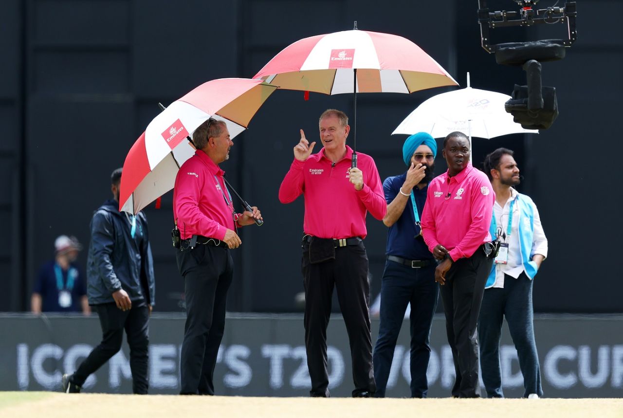 Umpires Paul Reiffel and Richard Illingworth protect themselves from the rain in Tarouba, New Zealand vs PNG, Tarouba,T20 World Cup 2024, June 17, 2024