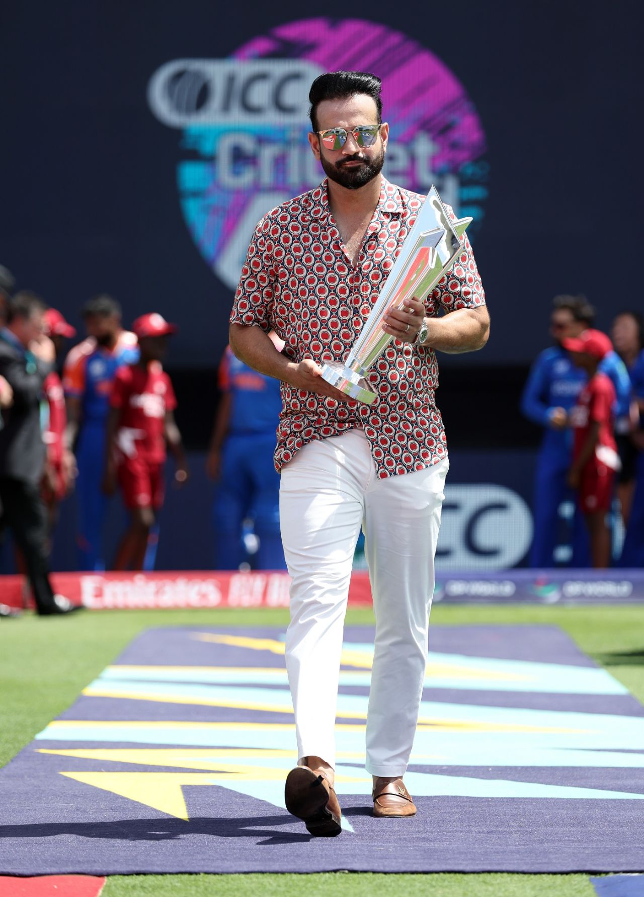 Former India allrounder Irfan Pathan carries the T20 World Cup trophy to the field of play, Afghanistan vs India, T20 World Cup Super Eight, Bridgetown, June 20, 2024
