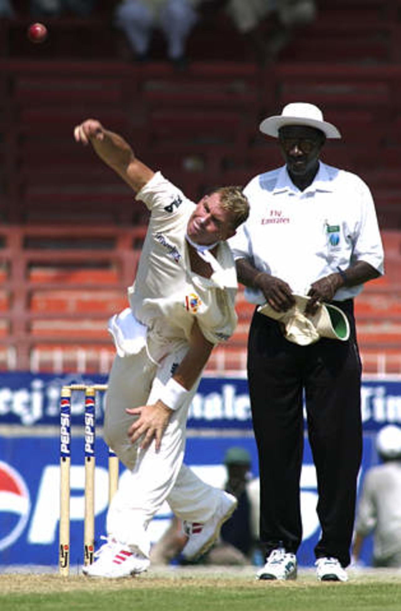 Australia leg spinner Shane Warne bowls Pakistan captain Waqar Younis LBW, as umpire Steve Bucknor (R) watches during their second cricket test at Sharjah's stadium October 11, 2002. The second and third tests are being held in the neutral venue of Sharjah after Australia balked at playing in Pakistan due to security concerns.