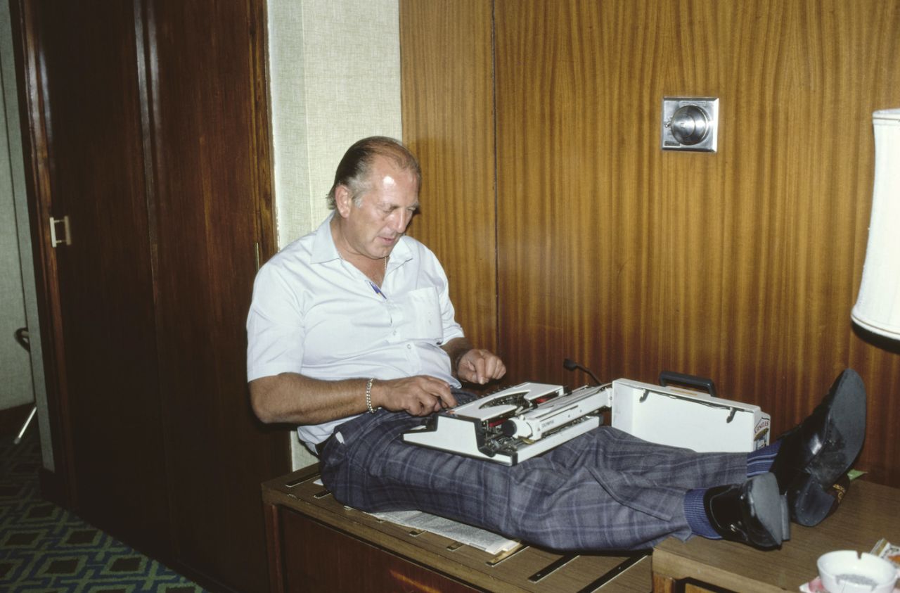Daily Mail journalist Peter Smith at work on a typewriter in a hotel room in Delhi, England tour of India, January 12, 1982