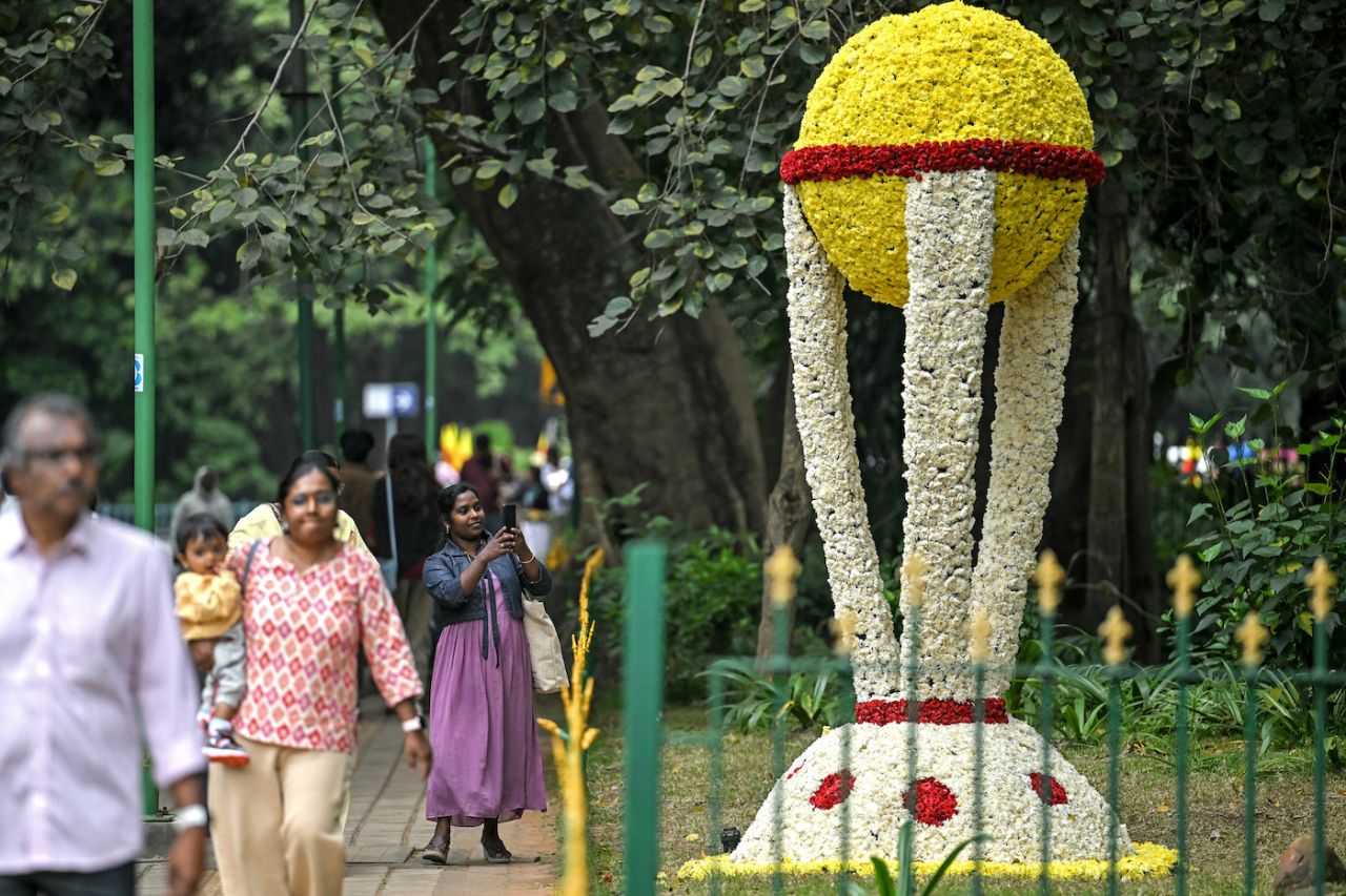 A visitor takes a photograph of a floral display representing the World Cup trophy, Cubbon Park in Bengaluru, November 30, 2024
