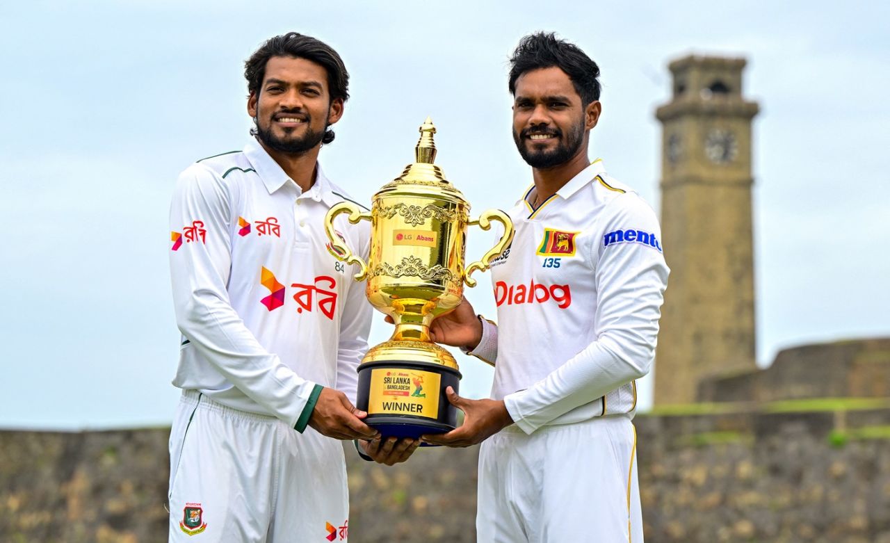 Najmul Hossain Shanto and Dhananjaya de Silva pose with the series trophy against the backdrop of the Galle fort, Galle, June 16, 2025