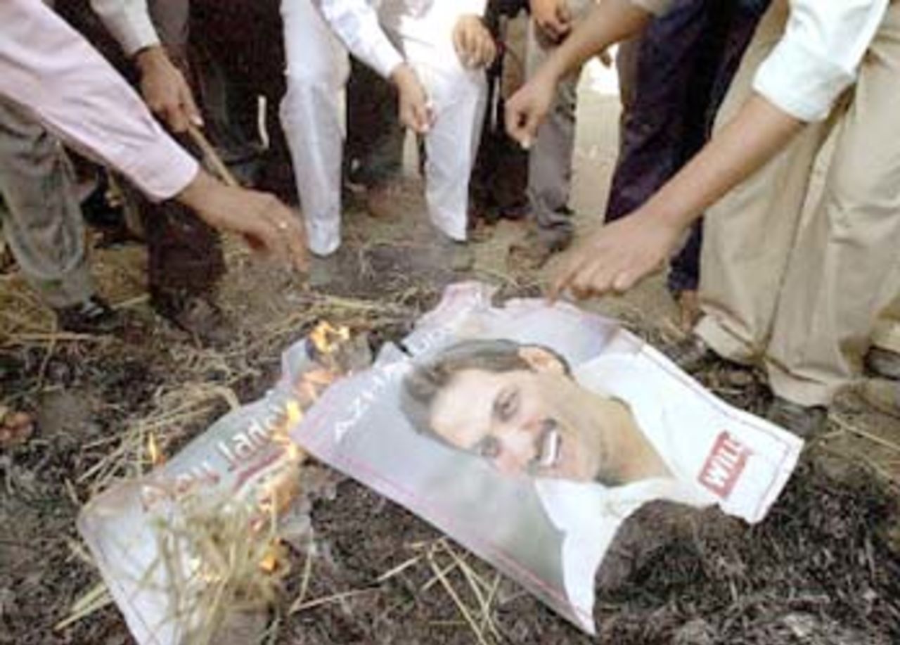 Youth activists of the Bharatiya Janata Party (BJP) burn posters in Bombay, 03 November 2000, of Indian cricketers Ajay Jadeja and Mohammad Azharuddin who were named in a Central Bureau of Investigation (CBI) report on cricket match-fixing. Azharuddin is alleged, not only to have rigged games for cash, but also to have attracted other players to match-fixing.