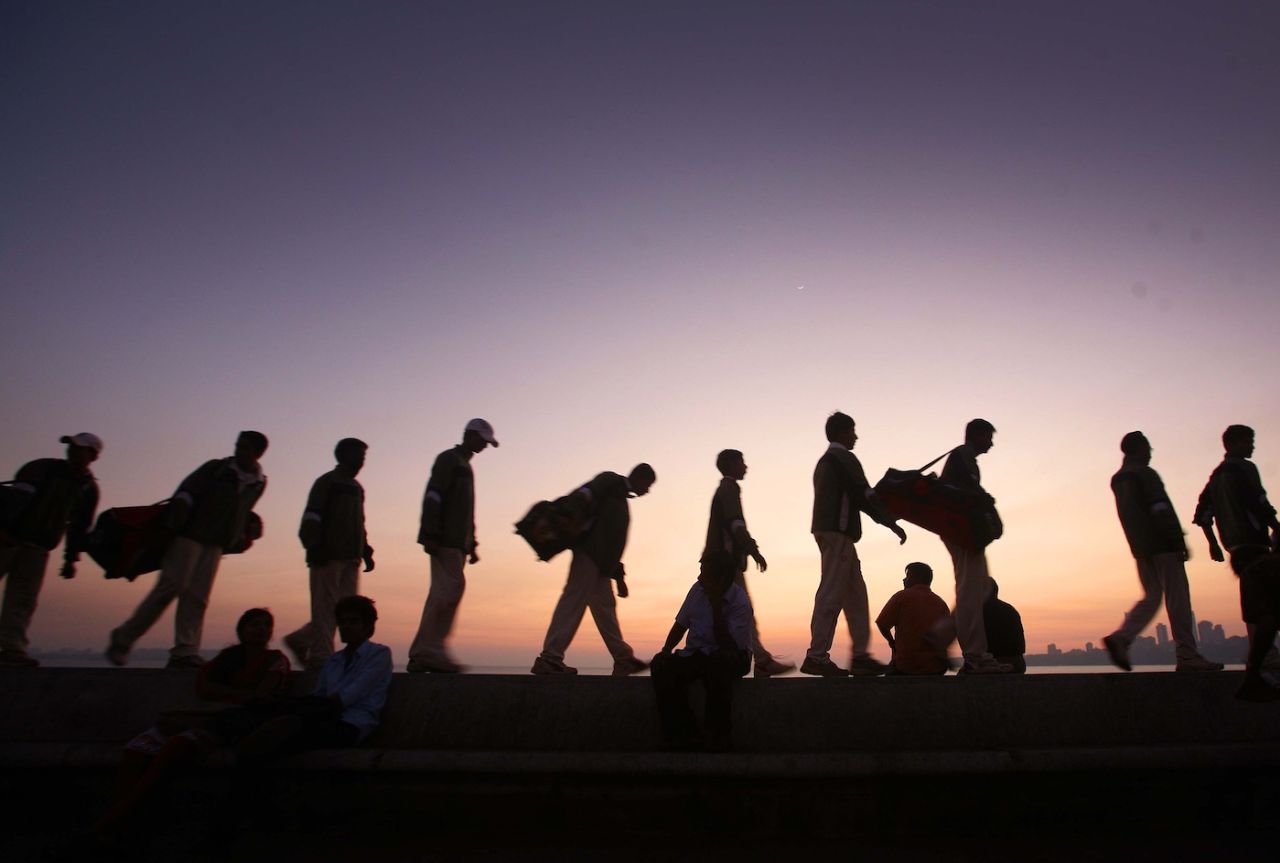 Cricket players walk the promenade on Marine Drive at sunset, Mumbai, December 27, 2011