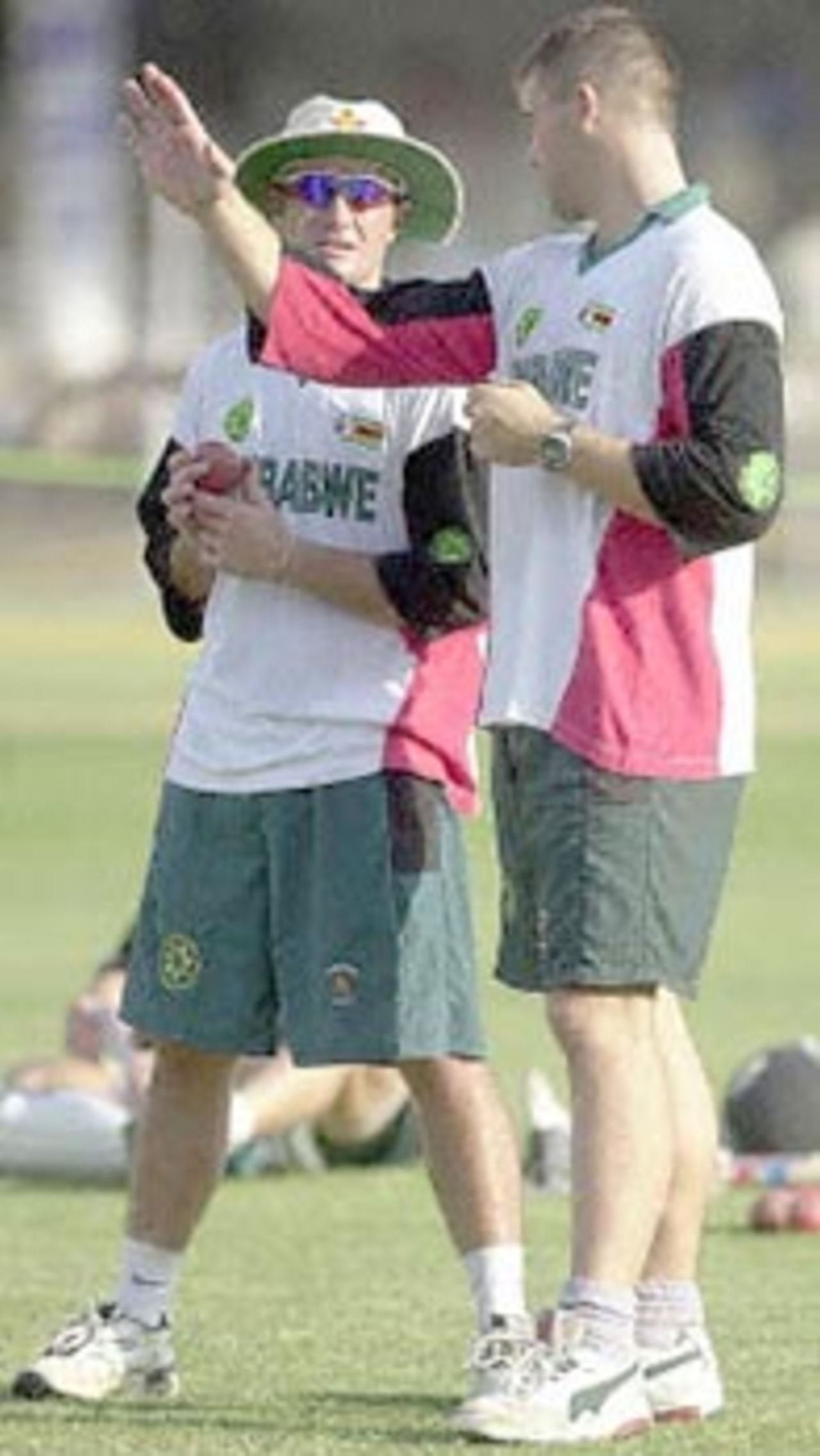 Zimbabwe cricket team captain Heath Streak (R) gives a few tips to teammate Dirk Viljoen during a practise session in Nagpur, 24 November 2000 on the eve of the second test  match between India and Zimbabwe. India won the first test match to take a 1-0 lead in the two- match-series.