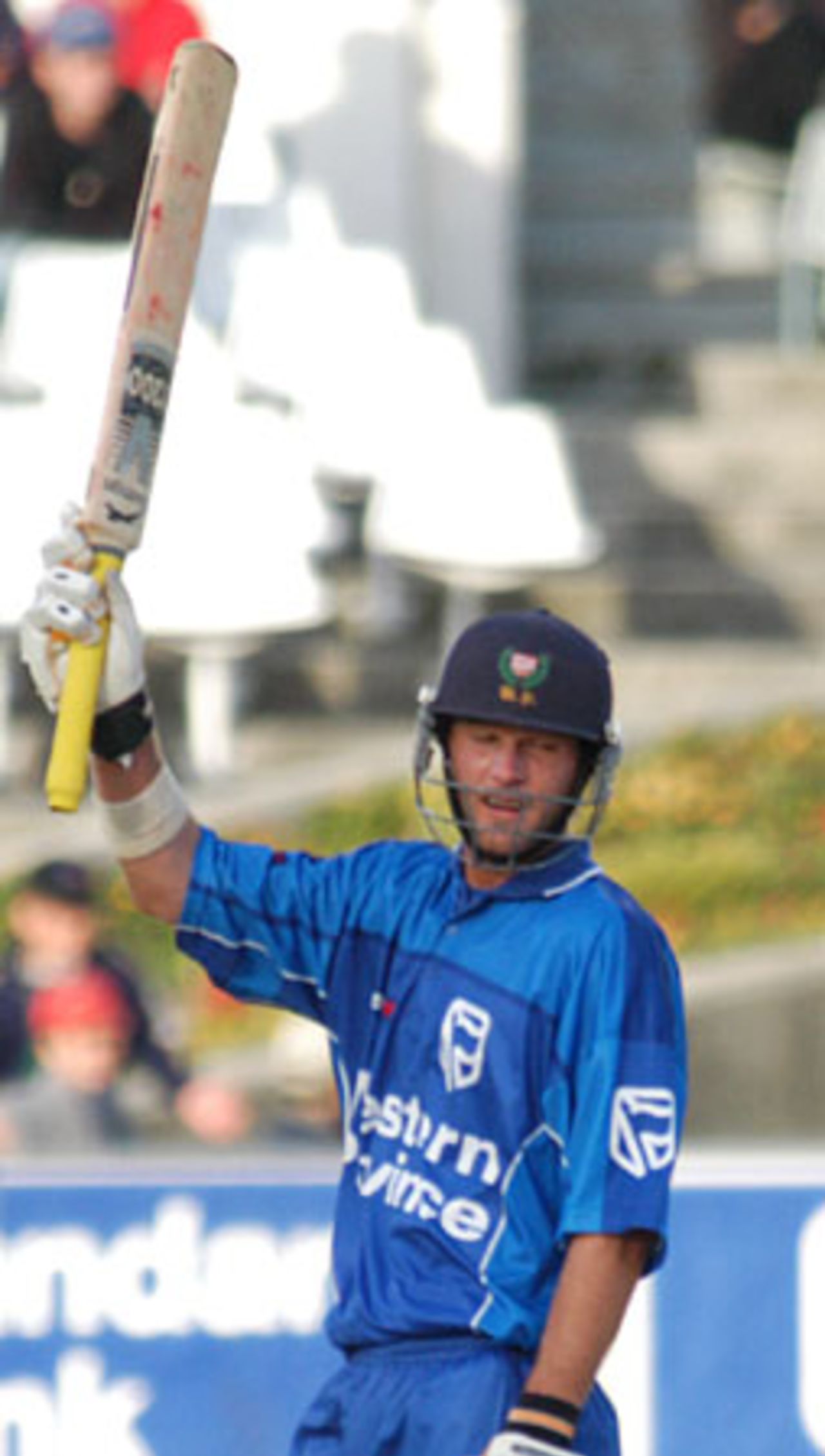 Andrew Puttick salutes  the crowd after reaching his half century