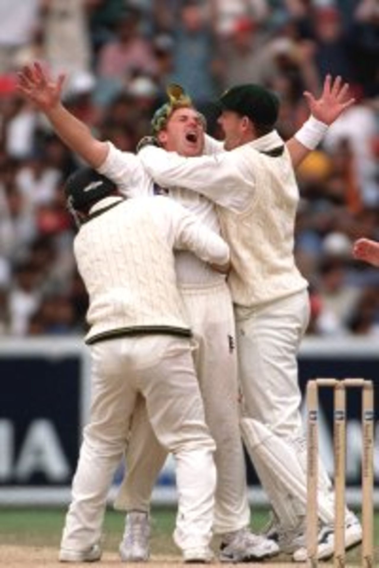 30 Dec 1999: Shane Warne of Australia is embraced by team mates Adam Gilchrist and Justin Langer as he celebrates the wicket of Sachin Tendulkar of India, on day five of the second test match between Australia and India at the Melbourne Cricket Ground, Melbourne, Australia. Tendulkar was judged LBW to Warne for 52 runs. Australia later won the match by 180 runs.