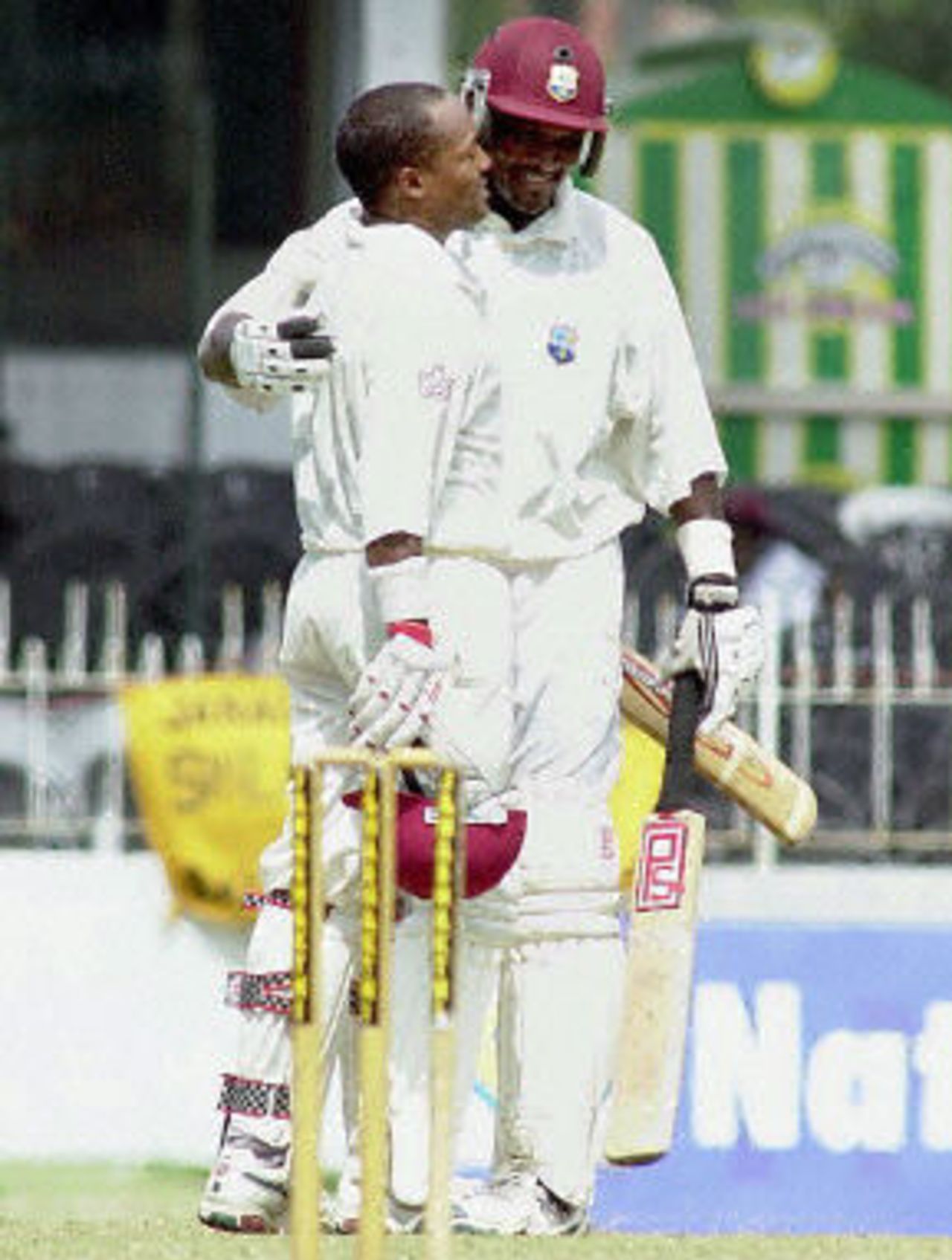 West Indies batsman Brian Lara celebrates as he completes his century with skipper Carl Hooper