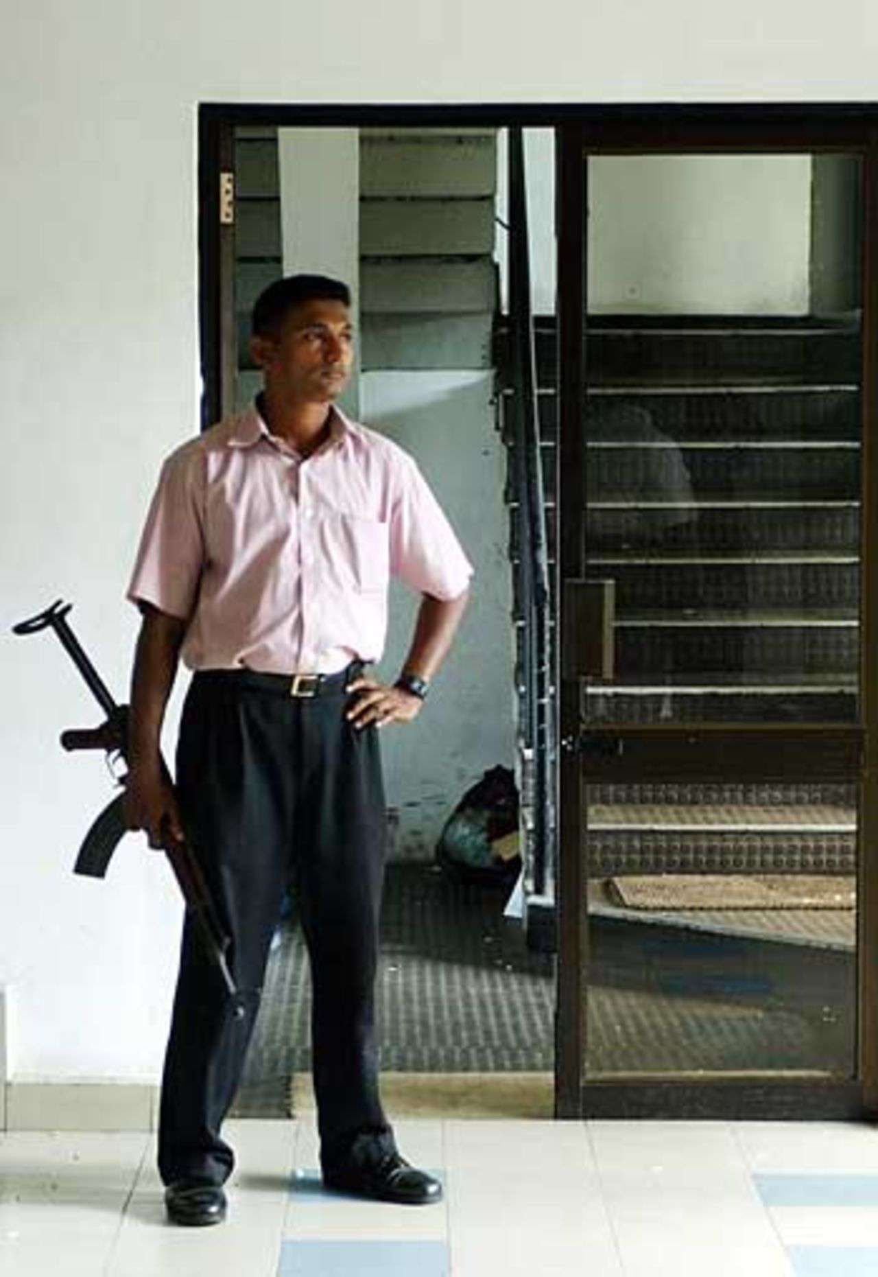 An armed plain-clothes police officer stands guard at the entrance to the Sri Lanka Cricket Board offices, Colombo, May 2