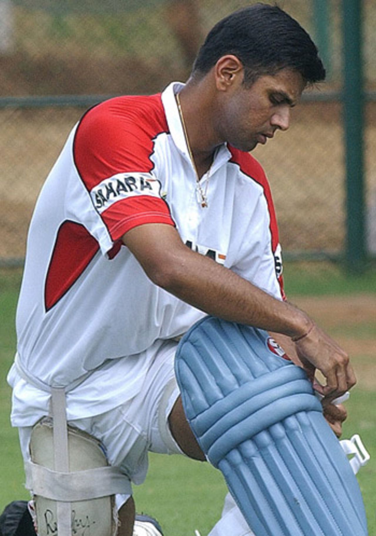 Rahul Dravid ties on a leg pad during a practice session, Dambulla, July 29, 2005