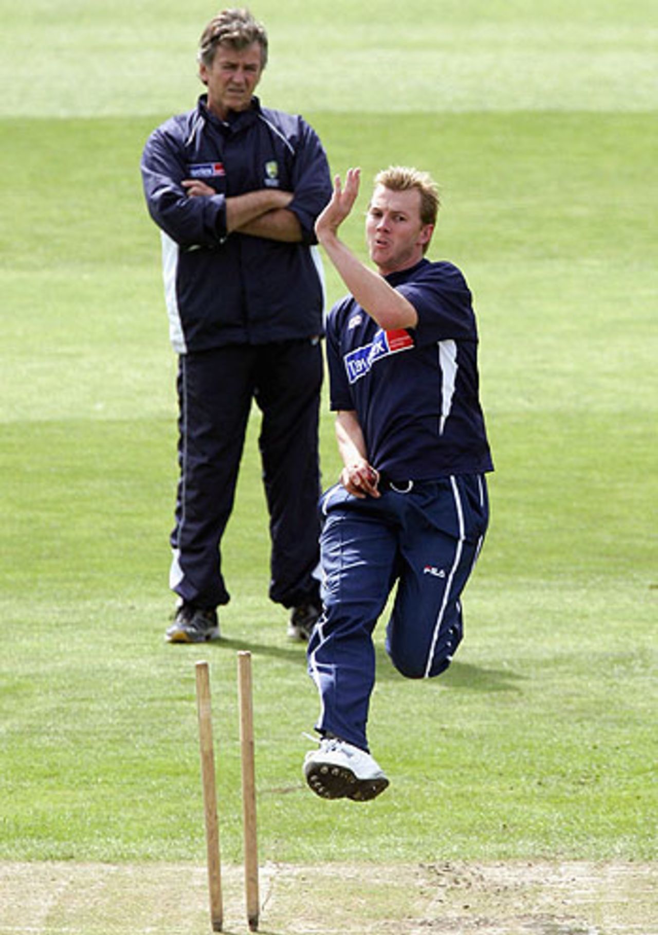 Brett Lee cranks up the pace in the Old Trafford nets, watched by the Australian physio, Errol Alcott, August 10, 2005