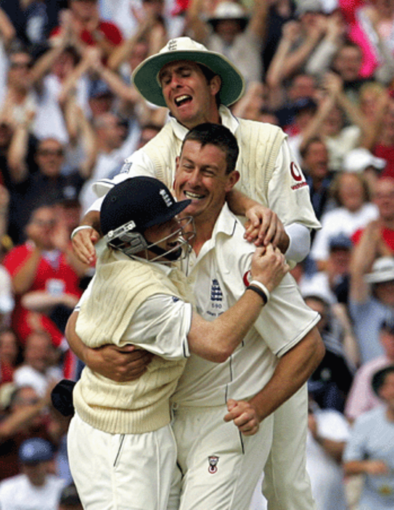 Michael Vaughan and Ian Bell hug Ashley Giles after Justin Langer's wicket, England v Australia, Old Trafford, August 12, 2005