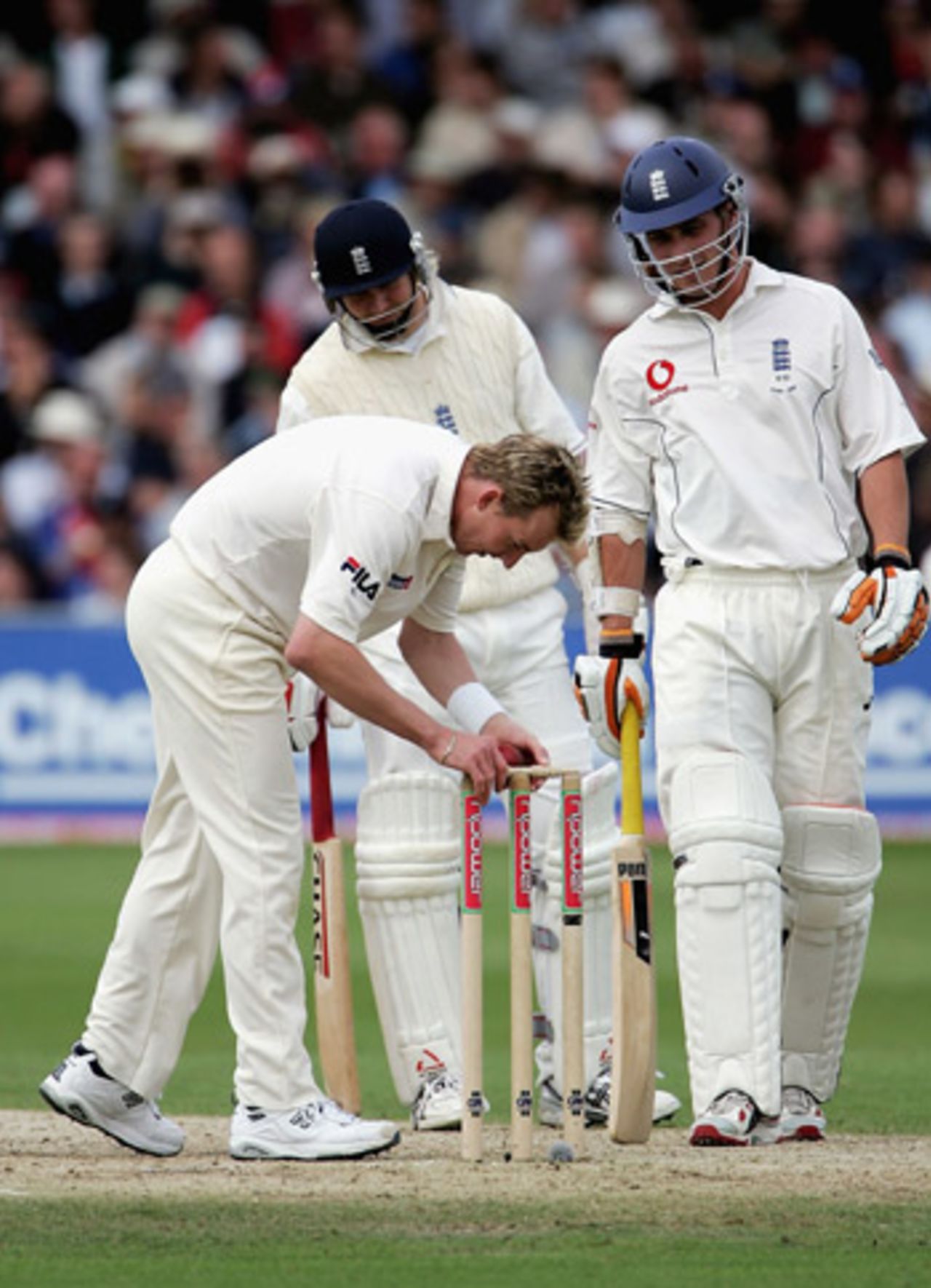 Brett Lee inspects the bails, when the ball rolled onto the stumps without dislodging them, watched on by Simon Jones and Matthew Hoggard