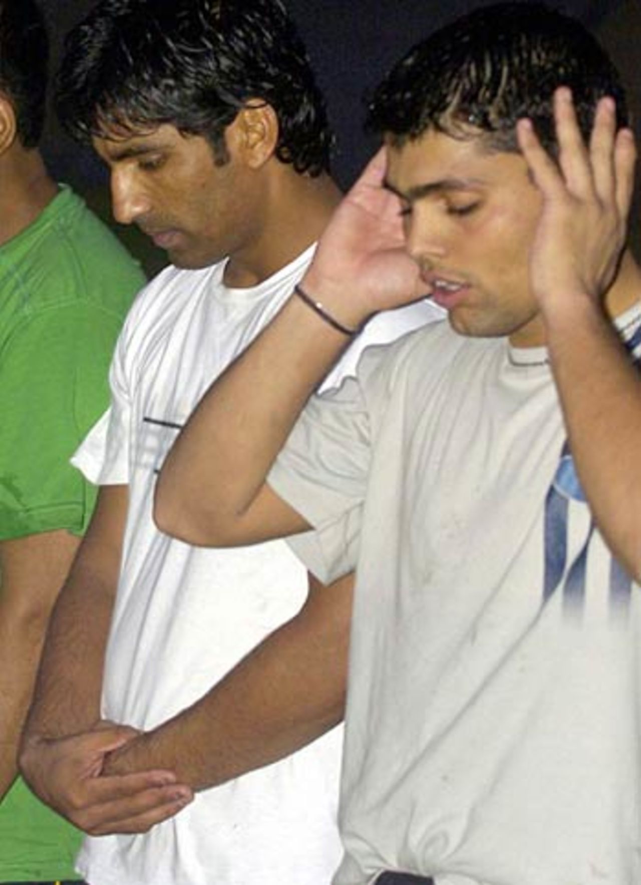 Yousuf Youhana offers prayers after embracing Islam with his team-mate Kamran Akmal at a mosque in Lahore, September 19, 2005