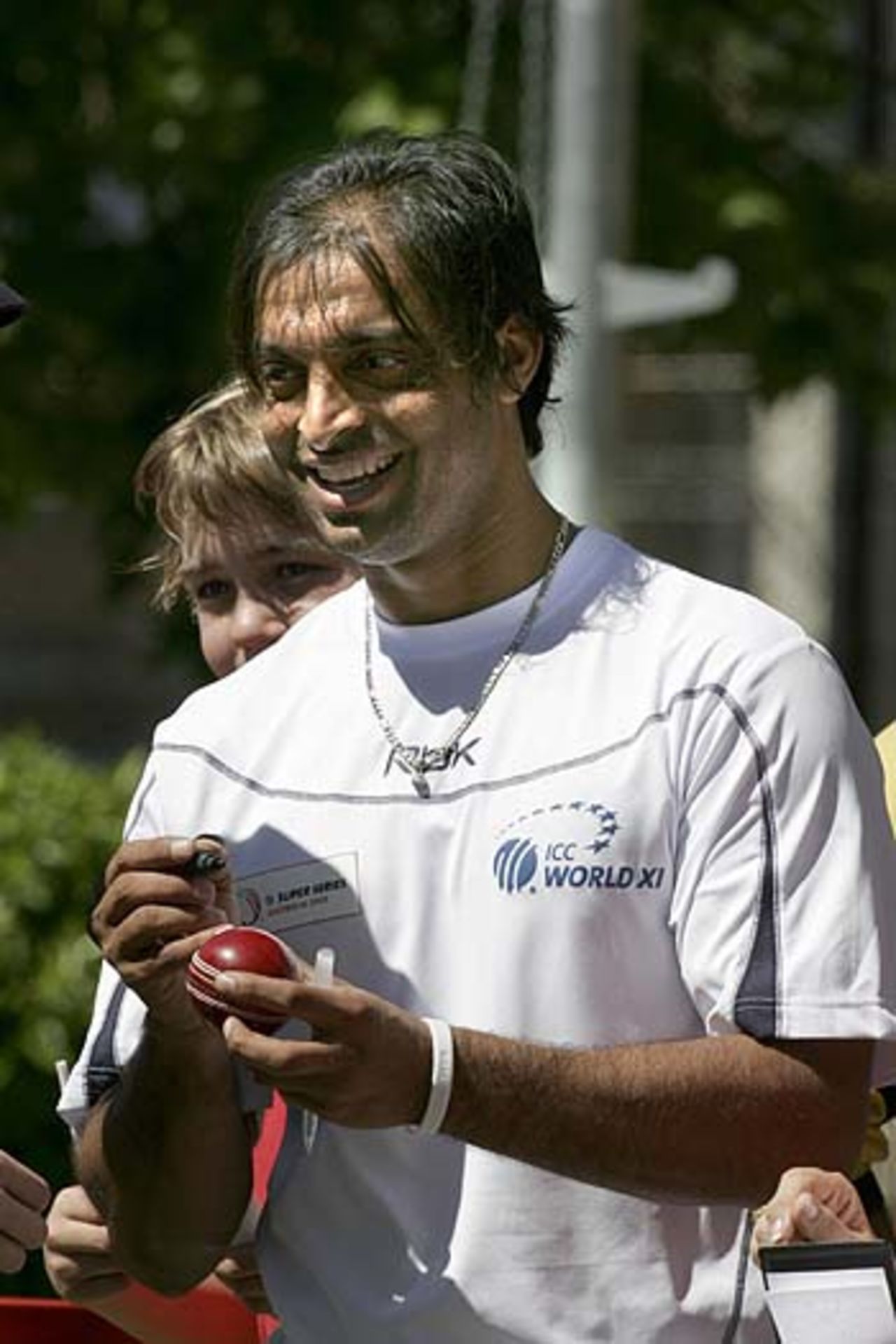 Shoaib Akhtar autographs a cricket ball for a fan ahead of the Super Test, Sydney Cricket Ground, October 11, 2005