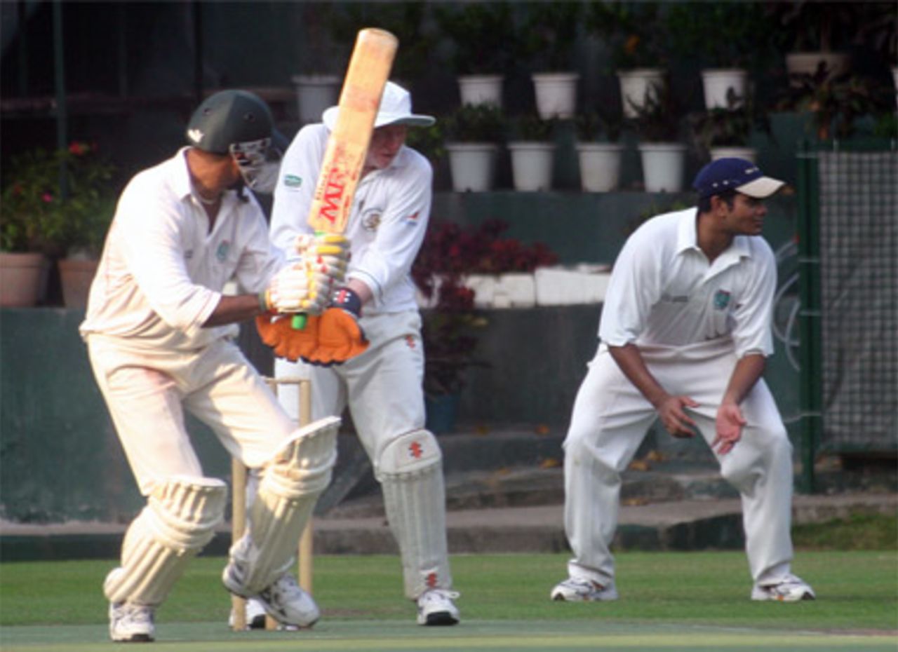 Naeem Ashraf cuts the ball past Ray Brewster and Manoj Cheruparambil