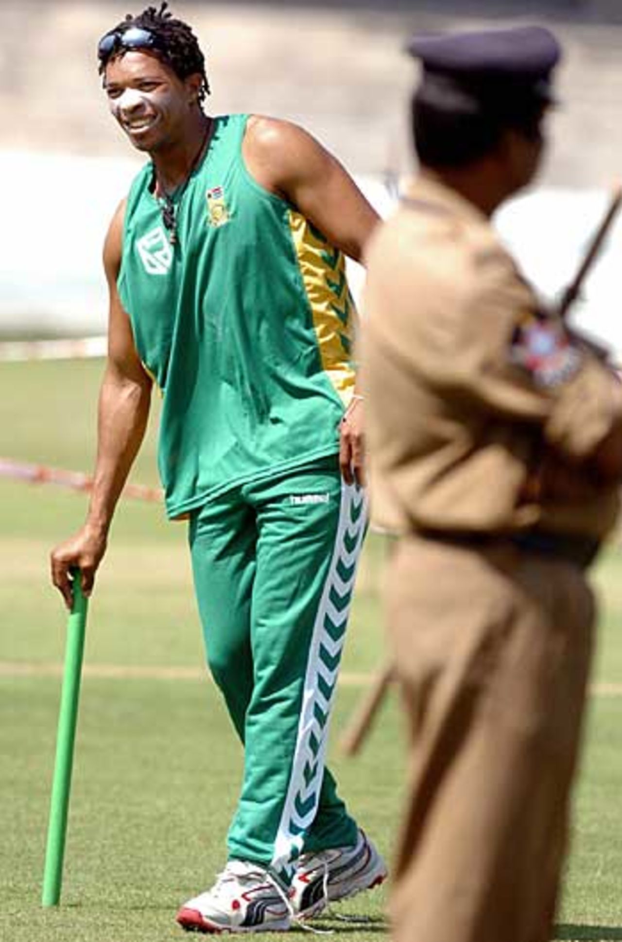 Makhaya Ntini chuckles in a net session, watched by a security guard, Hyderabad, November 13, 2005