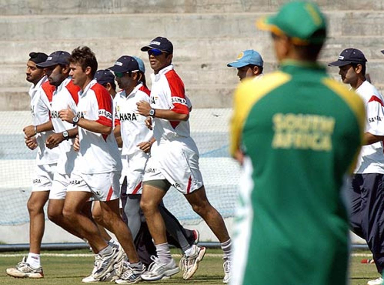 Indian cricketers jog around the ground as a South African player looks on, Rajiv Gandhi International Stadium, Uppal, Hyderabad, November 15, 2005