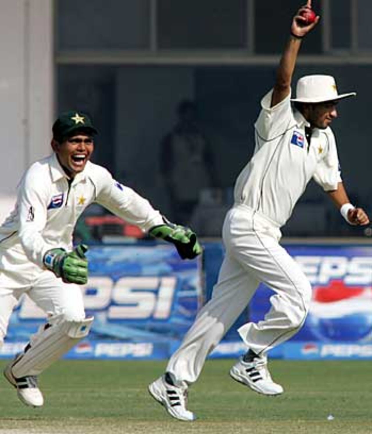 Kamran Akmal and Hasan Raza race towards Danish Kaneria to celebrate Andrew Strauss's wicket, Pakistan v England, 1st Test, Multan, November 16, 2005