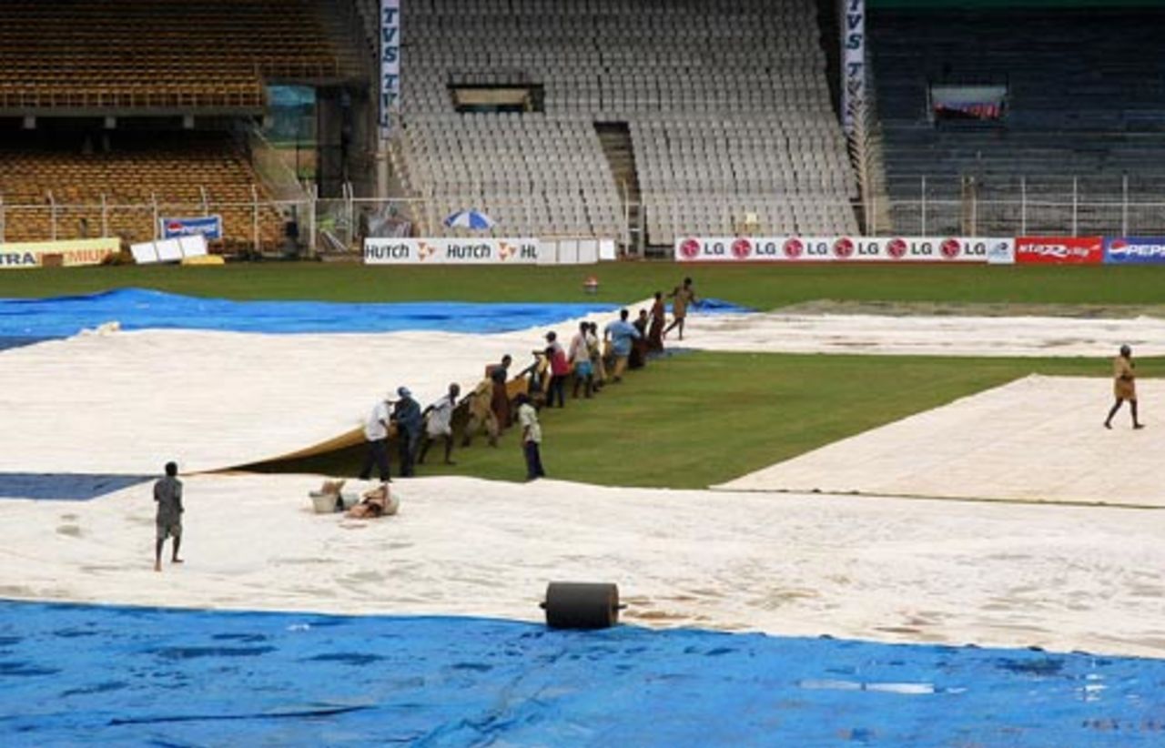 Groundsmen working overtime as rains lash Chennai ahead of the one-day match between India and South Africa, Chennai, November 21, 2005