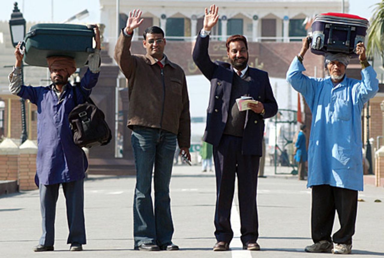 Indian cricket fans wave to reporters on crossing the India-Pakistan border on route to Lahore, January 12, 2006