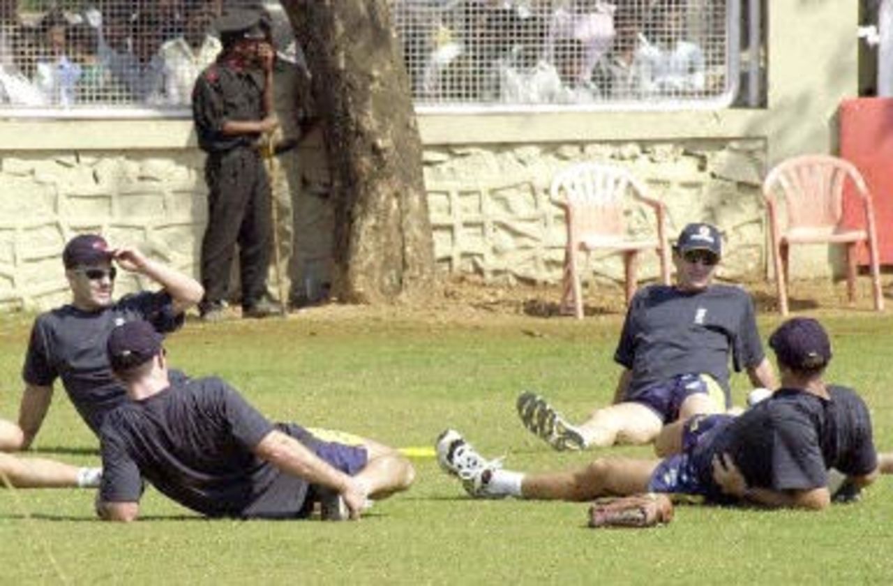 Indian cricket fans (background) watch members of the Australian cricket team warm up at the nets in Bombay, 15 February 2001, at the MIG stadium. They will be playing three test and five one-day international matches during their India tour.
