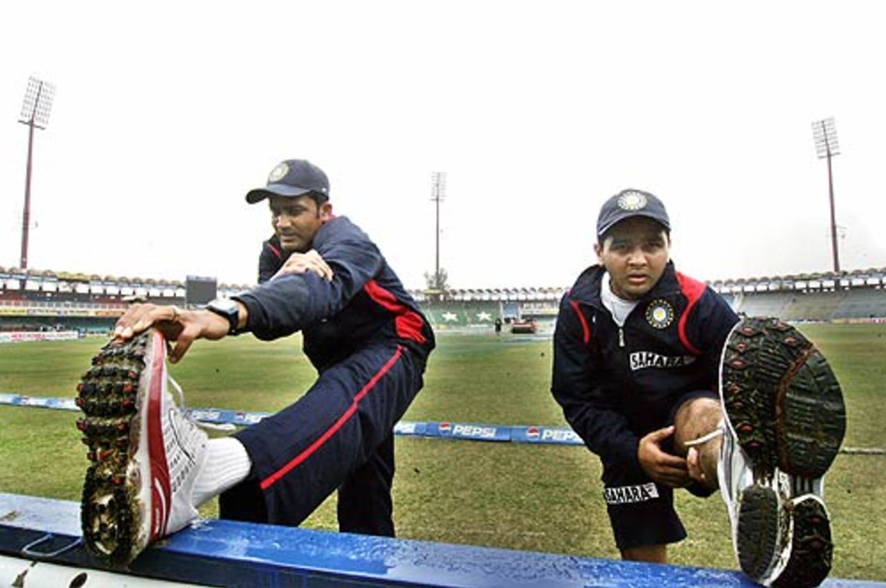 Anil Kumble and Parthiv Patel stretch as they wait for play to begin, India in Pakistan, 1st Test, Lahore, January 17, 2006