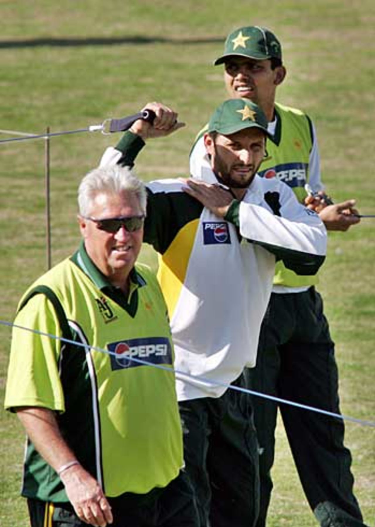 Bob Woolmer oversees a training session, with Shahid Afridi (middle) and Kamran Akmal in the background, Peshawar, February 4, 2006