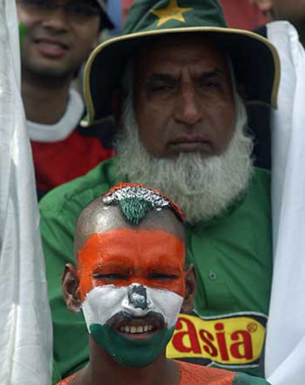 Contrasting supporters: Pakistan's biggest cricket fan, Chacha Cricket (Uncle Cricket), sits behind an Indian fan, Pakistan v India, 3rd ODI, Lahore, February 13, 2006